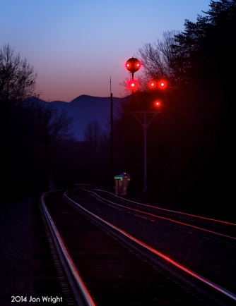 H73.4 ACORN HILL AT DUSK: The peaks of Massanutten Mountain loom behind the N&W color position light signals that guard the interlocking at the south end of the Bentonville siding in the Shenandoah Valley of Virginia.